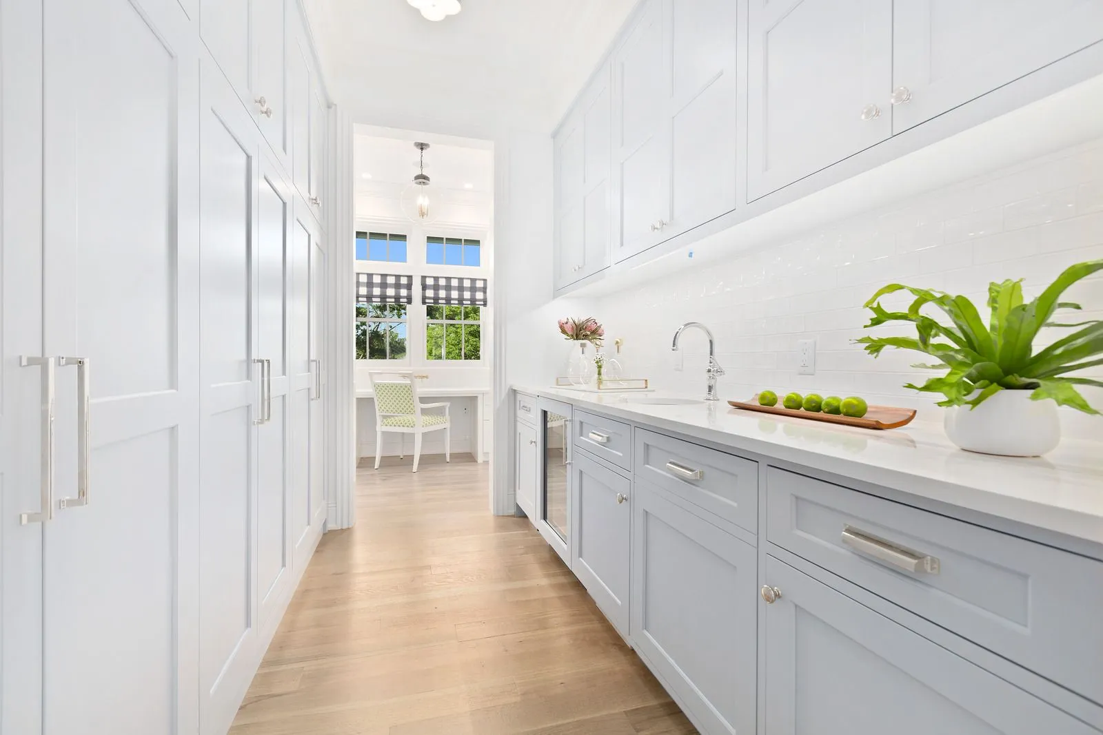 "Modern white kitchen with light wood flooring and quartz countertops in Centennial, CO"