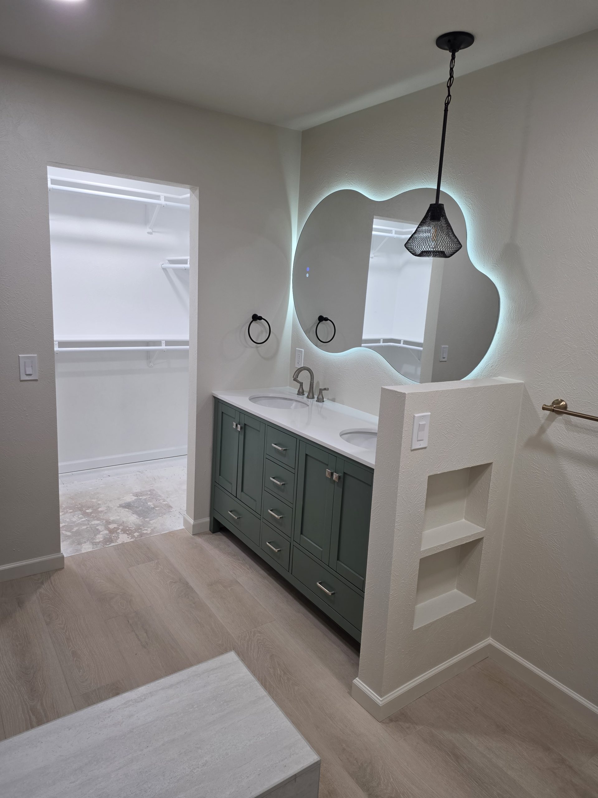 Completed bathroom remodel with tiled shower, vanity and wood-look plank floor in Littleton, CO