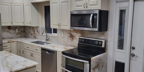 Kitchen remodel with cream cabinetry, marble backsplash, and tile flooring