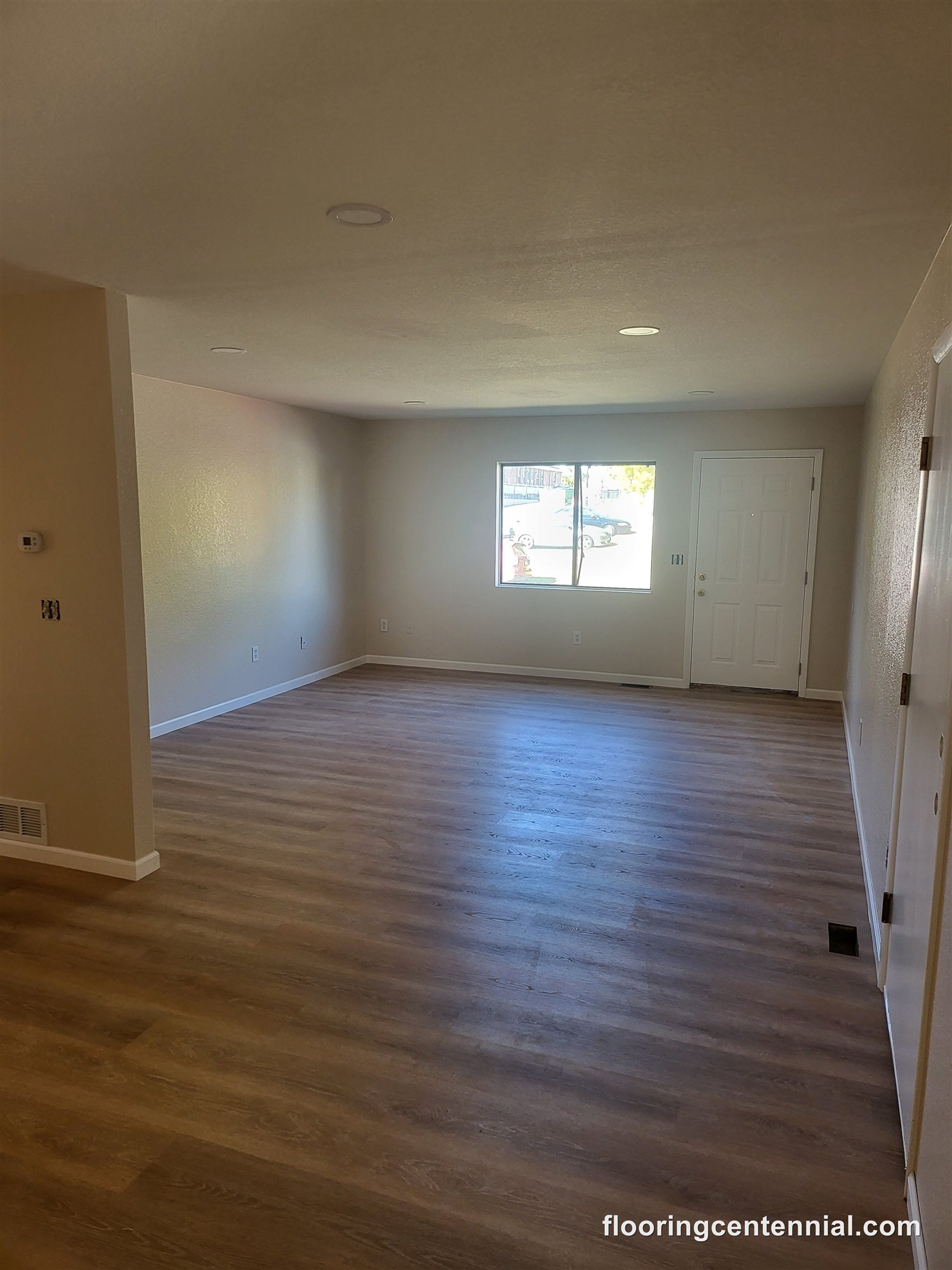 Open living room with wood-look vinyl plank flooring and natural light