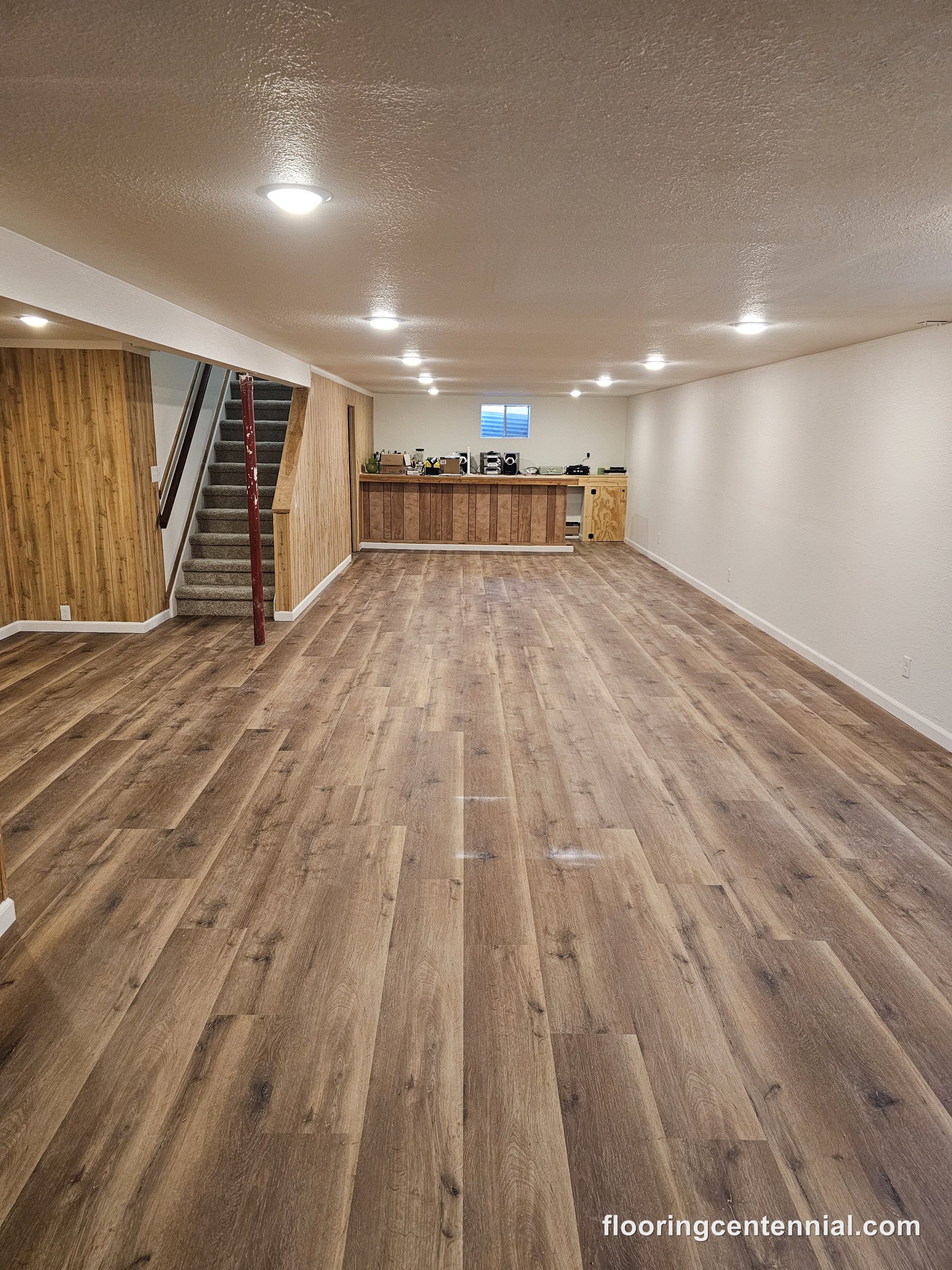 Large open finished basement with wide-plank wood-look vinyl flooring