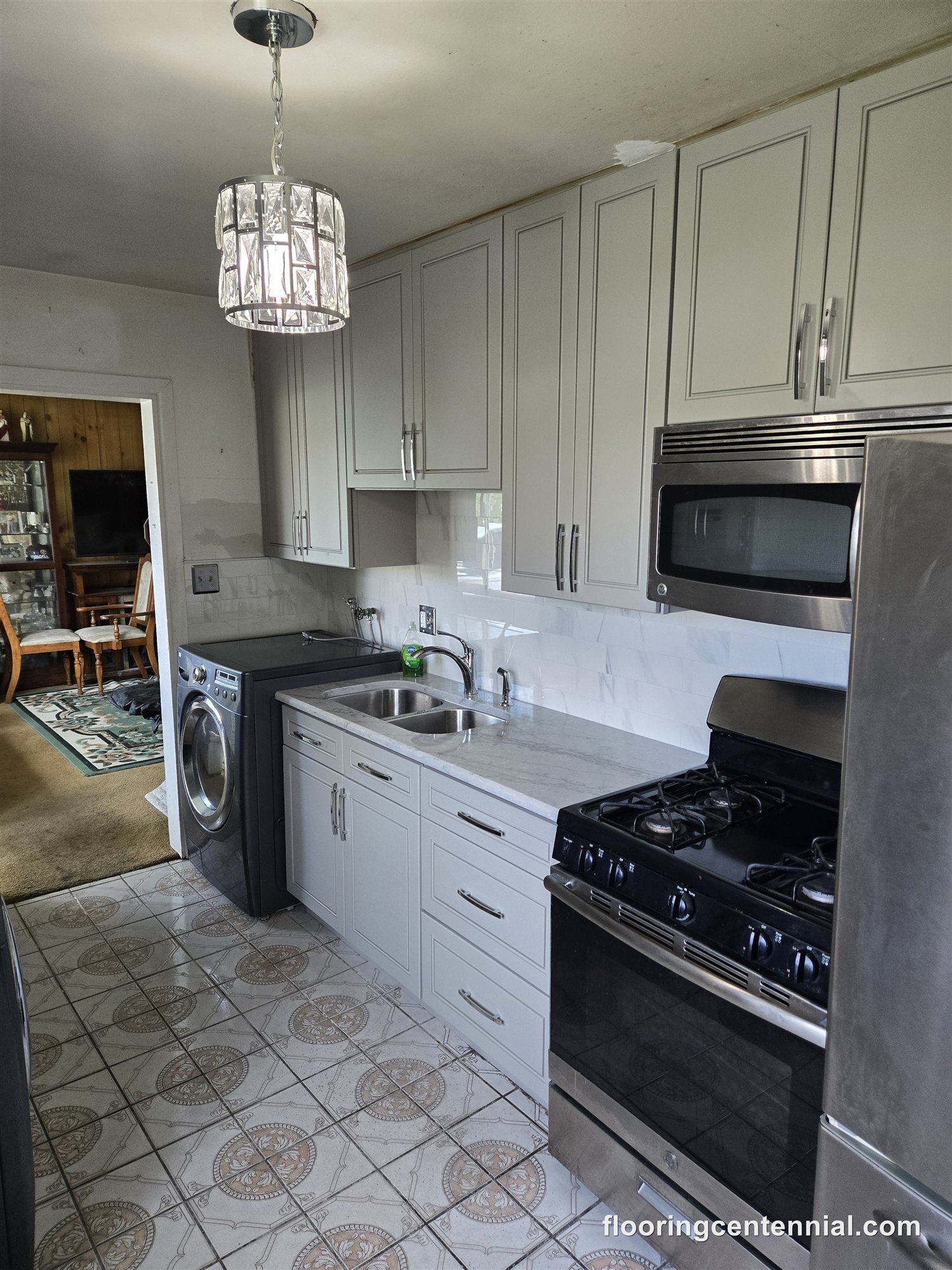 Kitchen and laundry remodel with gray cabinetry, marble subway tile, and quartz counters