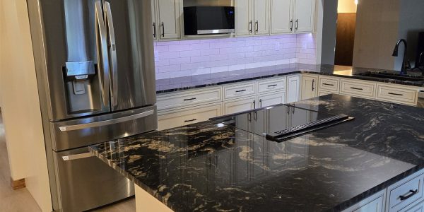Luxury kitchen remodel with cream cabinetry and black granite island