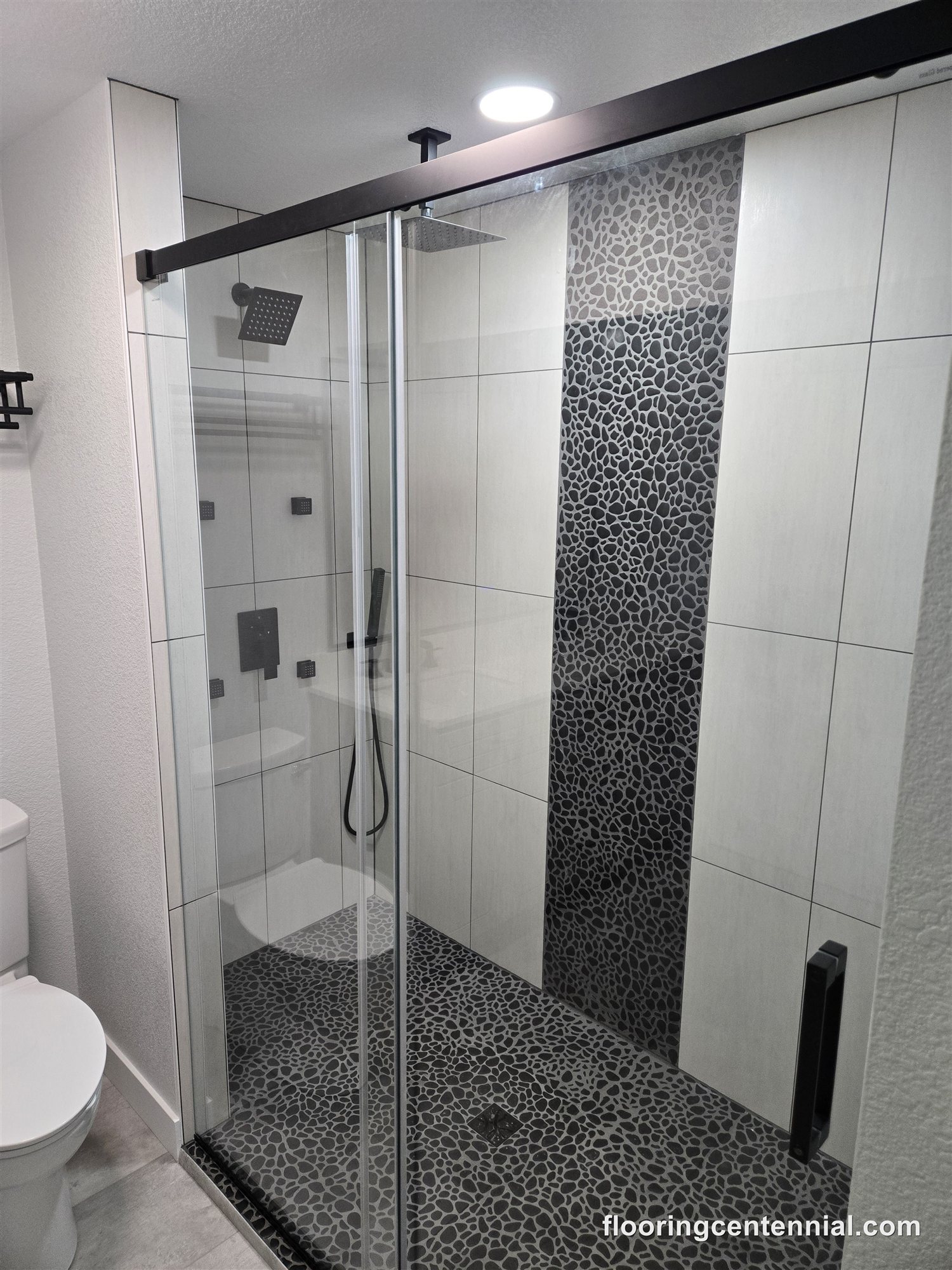Basement bathroom with new tile shower, glass door and accent wall, Aurora CO