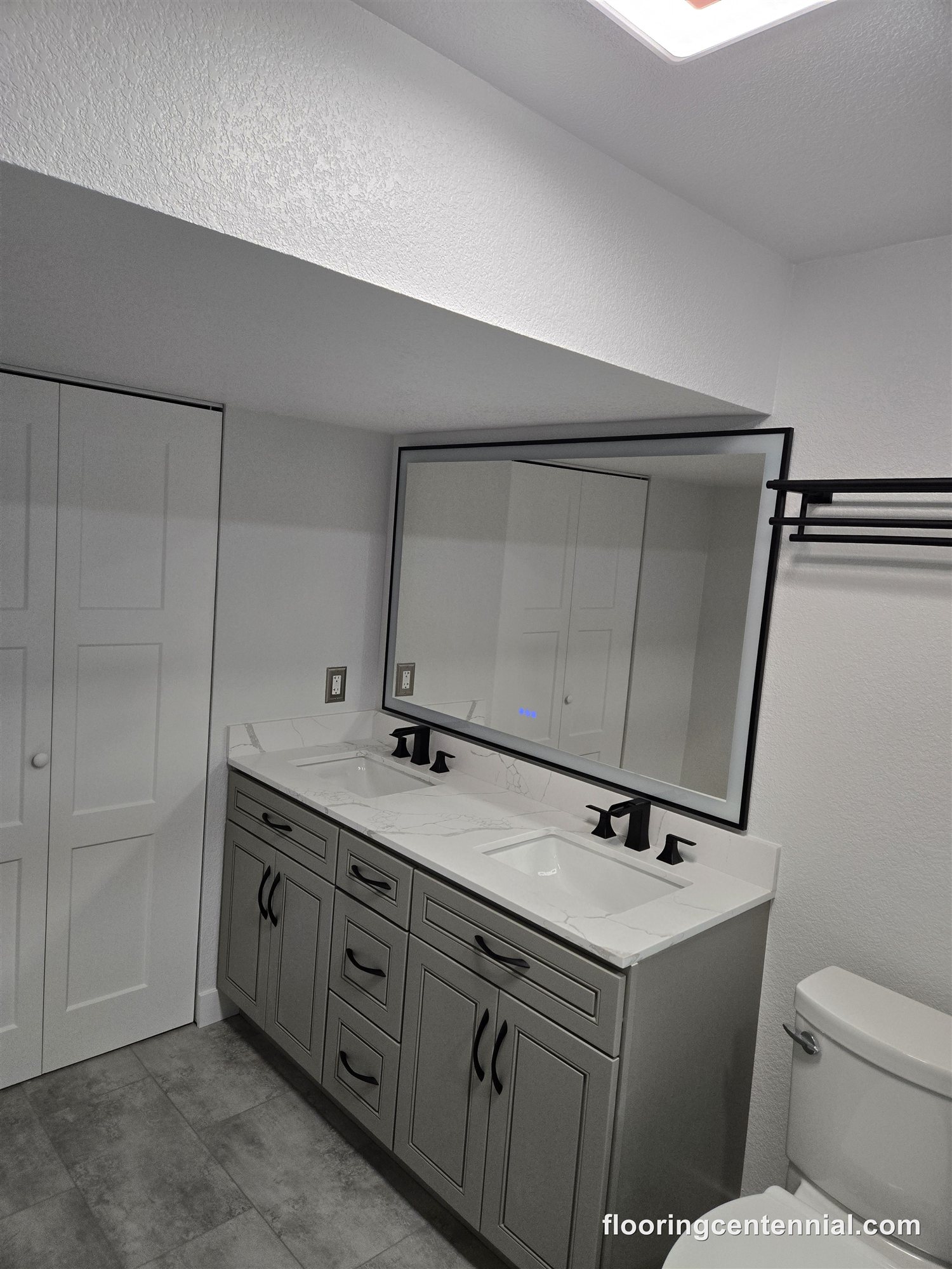 New vanity with mirror and lighting in a remodeled Aurora basement bathroom