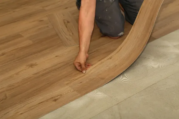 Installer laying luxury vinyl plank flooring in the Denver Metro area